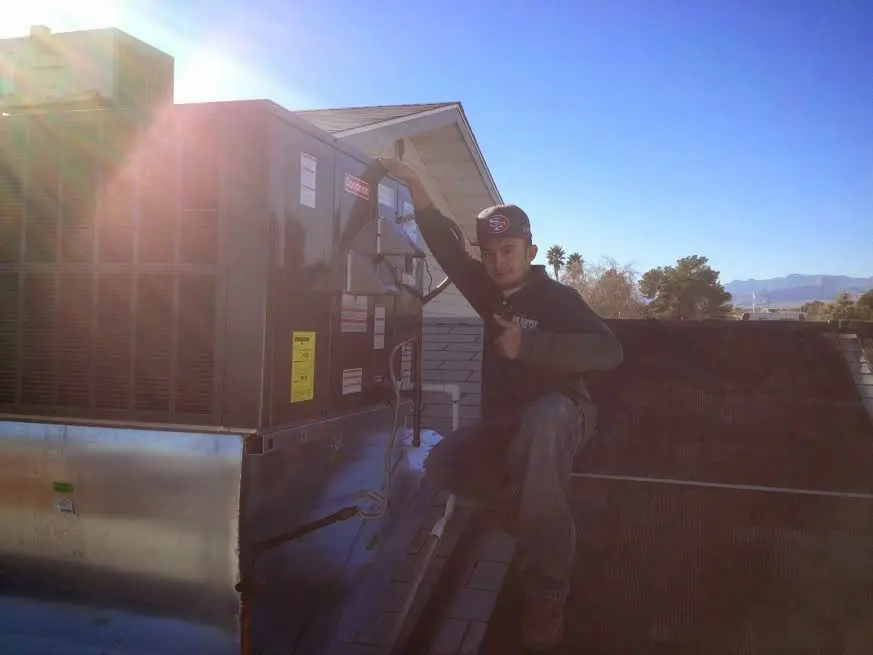HVAC technician performing AC Tune-Up on a rooftop unit in Fort Meade